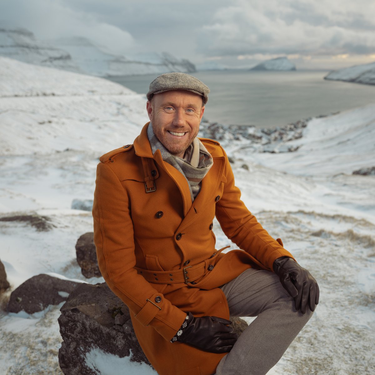 Hagen Vinter sitter på en stein i snødekt landskap